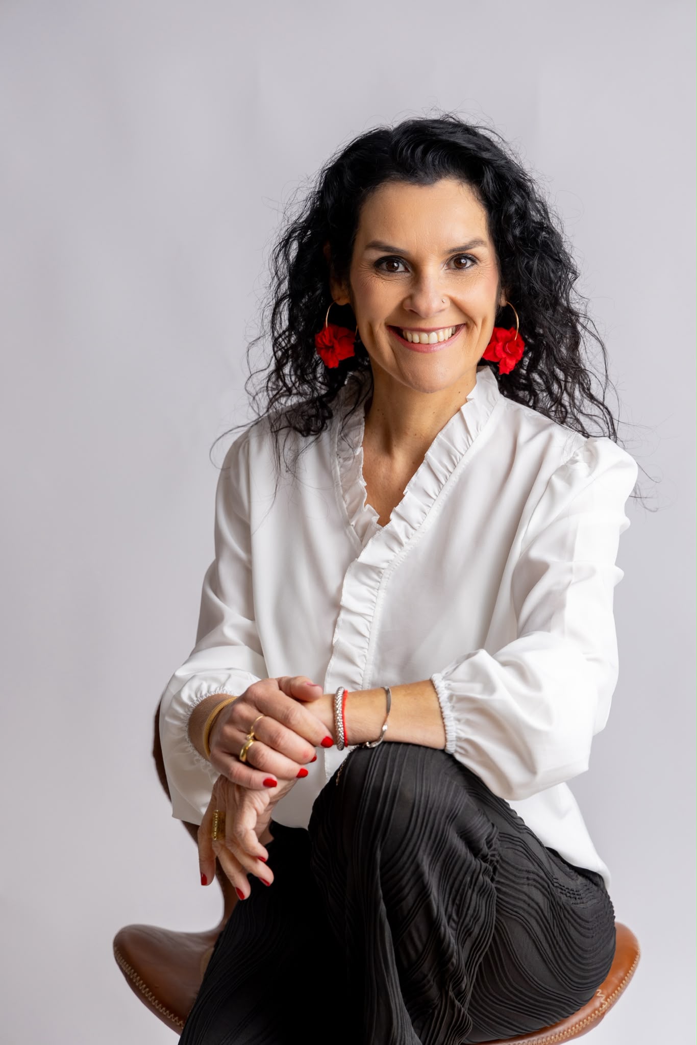 Lu Rodrigues sentada, sorrindo para a câmera